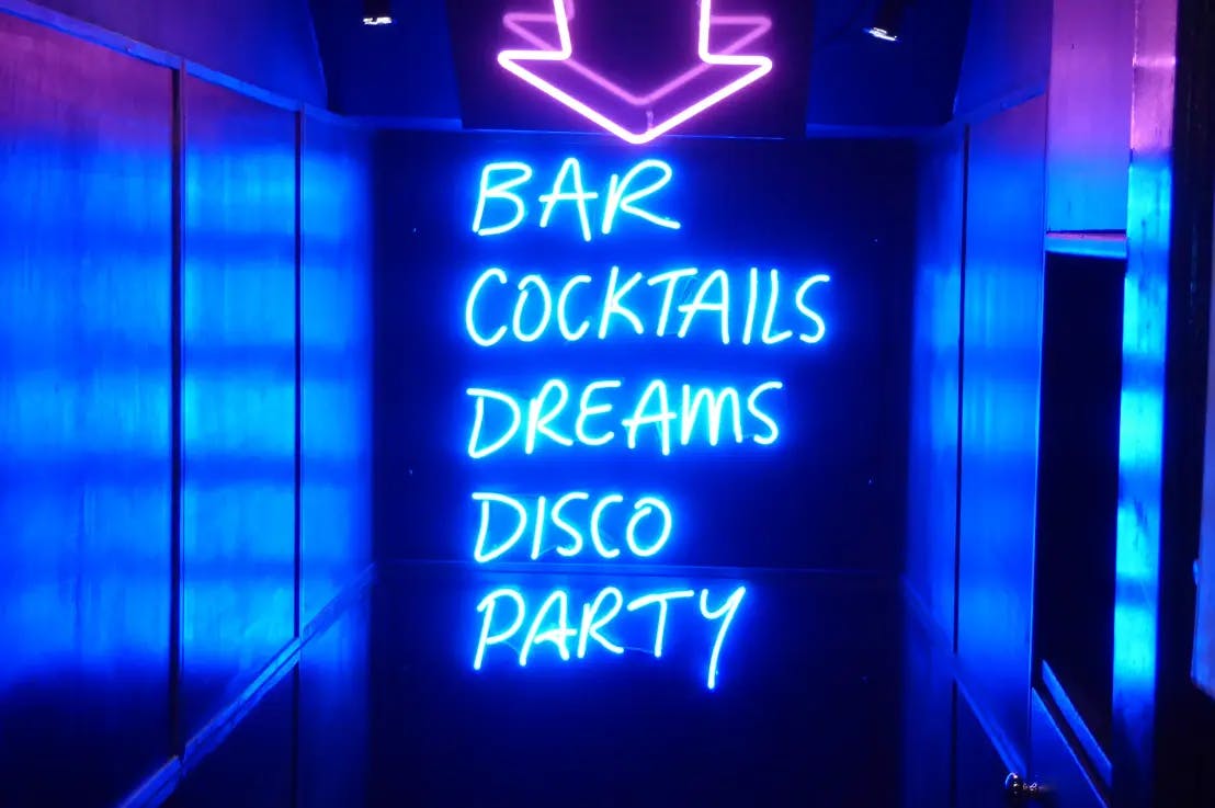 Neon sign at the entrance of a bar